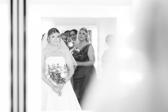 Bride looking in Mirror with bridesmaids